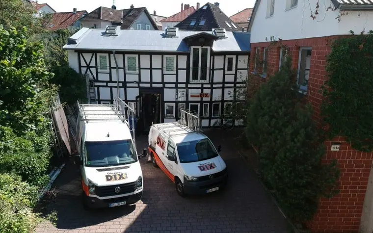 Betriebsgelände der Glaserei DIX in Braunschweig mit Fachwerkhaus und zwei Firmenfahrzeugen
